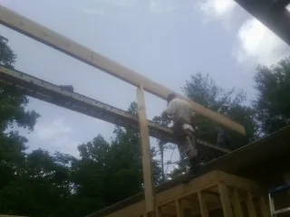 Carpenter setting a ridge beam over a new addition frame — Ice Dam Removal by Roofing Brothers in Russiaville