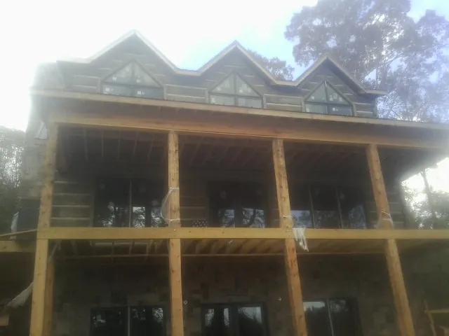 Dormers and porch framing on a large log home under construction — Roof Coating work by our crew in Russiaville