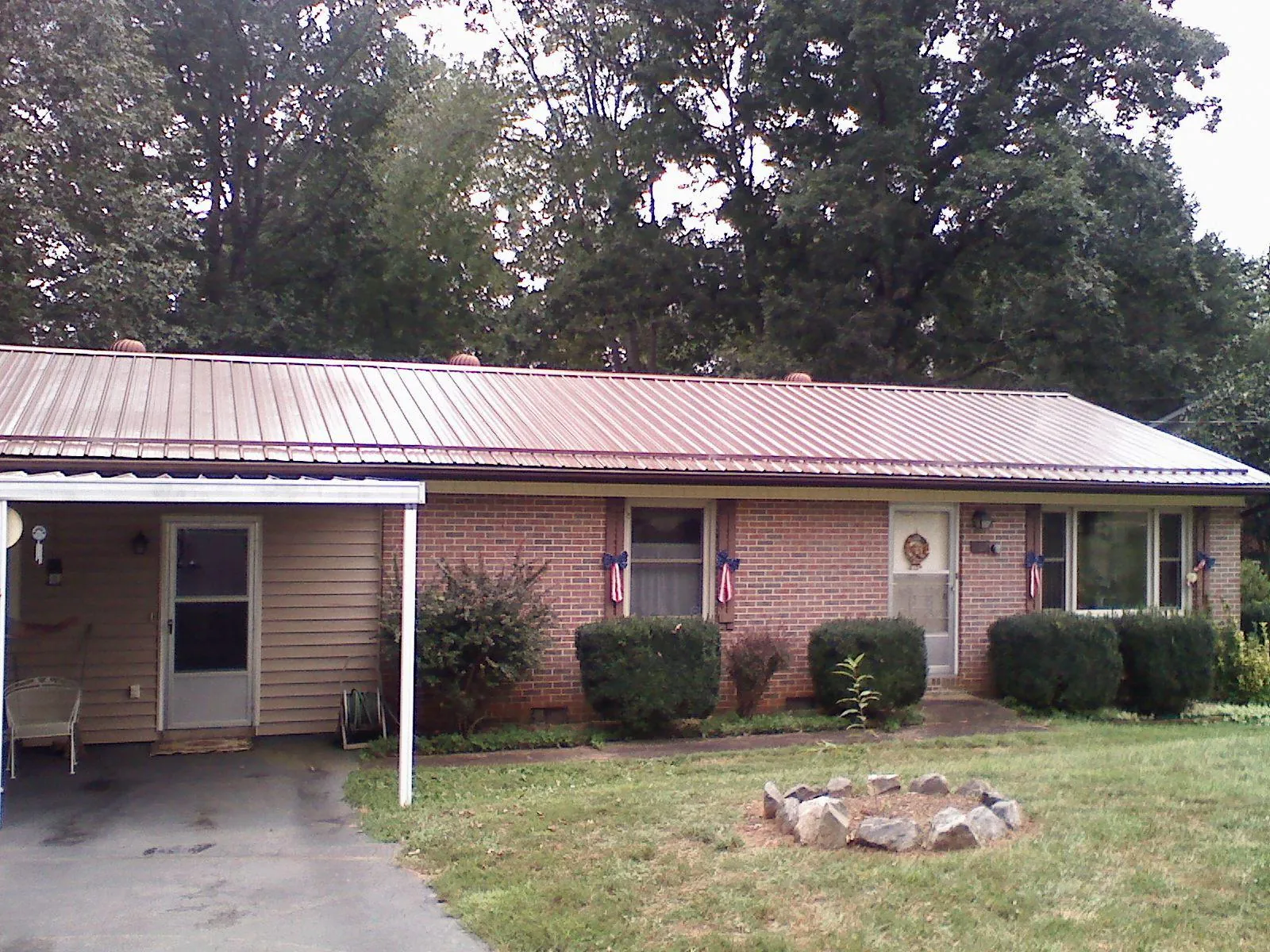 Bronze metal roof and carport on a brick ranch home — Roof Repair work by our crew in Russiaville